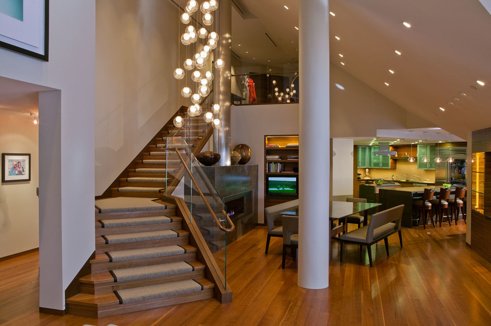 Mittelgroße Moderne Wohnküche mit weißer Wandfarbe, braunem Holzboden, Gaskamin, gefliester Kaminumrandung und gewölbter Decke in Denver