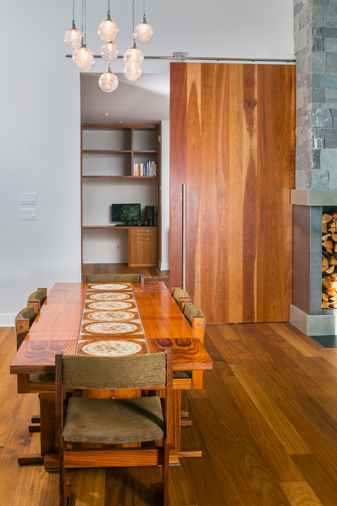Aménagement d'une salle à manger ouverte sur le salon moderne de taille moyenne avec un mur blanc et un sol en bois brun.