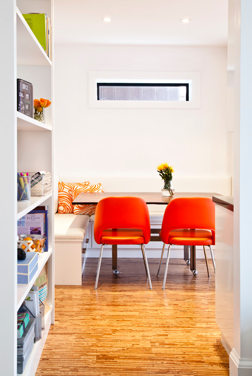 Immagine di una piccola sala da pranzo aperta verso la cucina minimalista con pareti bianche e parquet chiaro