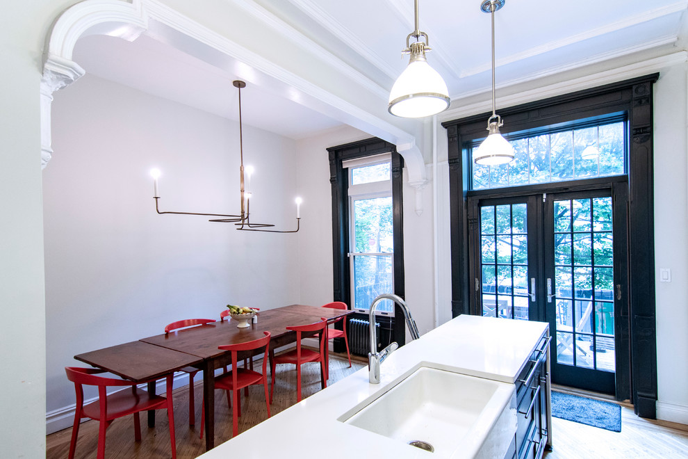 Immagine di una sala da pranzo aperta verso la cucina tradizionale di medie dimensioni con pareti grigie, pavimento in legno massello medio e pavimento marrone