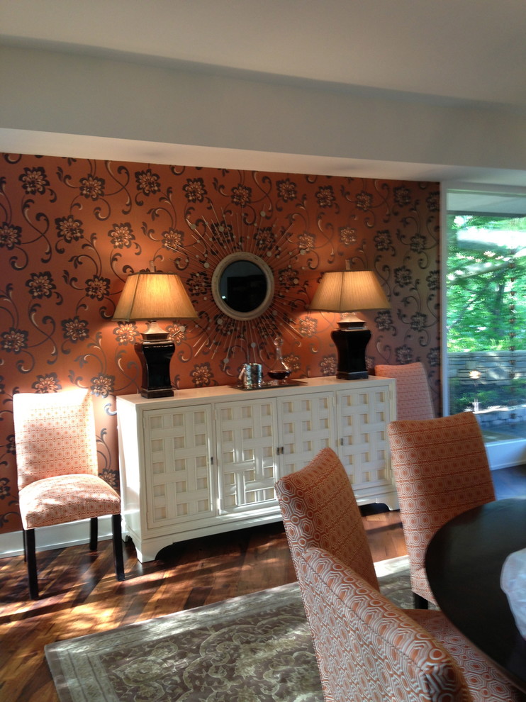 Esempio di un'ampia sala da pranzo aperta verso il soggiorno contemporanea con pareti arancioni e pavimento in legno massello medio
