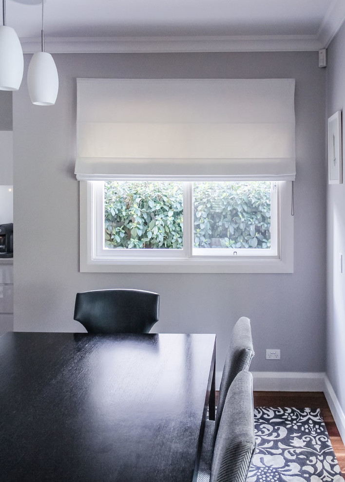 Ispirazione per una sala da pranzo minimalista chiusa con pareti grigie e pavimento in legno massello medio