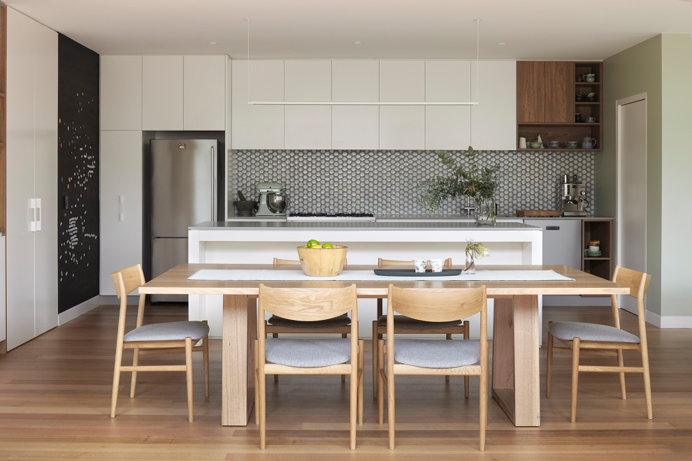 Idée de décoration pour une grande salle à manger ouverte sur la cuisine design avec un mur vert et un sol marron.