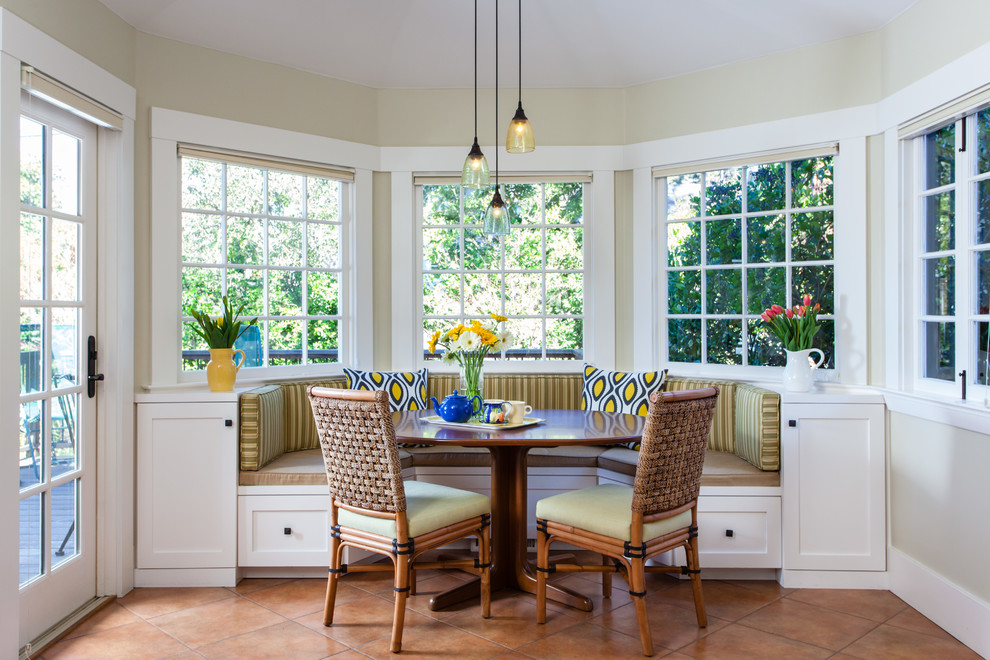 Стильный дизайн: кухня-столовая в классическом стиле с желтыми стенами, полом из терракотовой плитки и коричневым полом - последний тренд