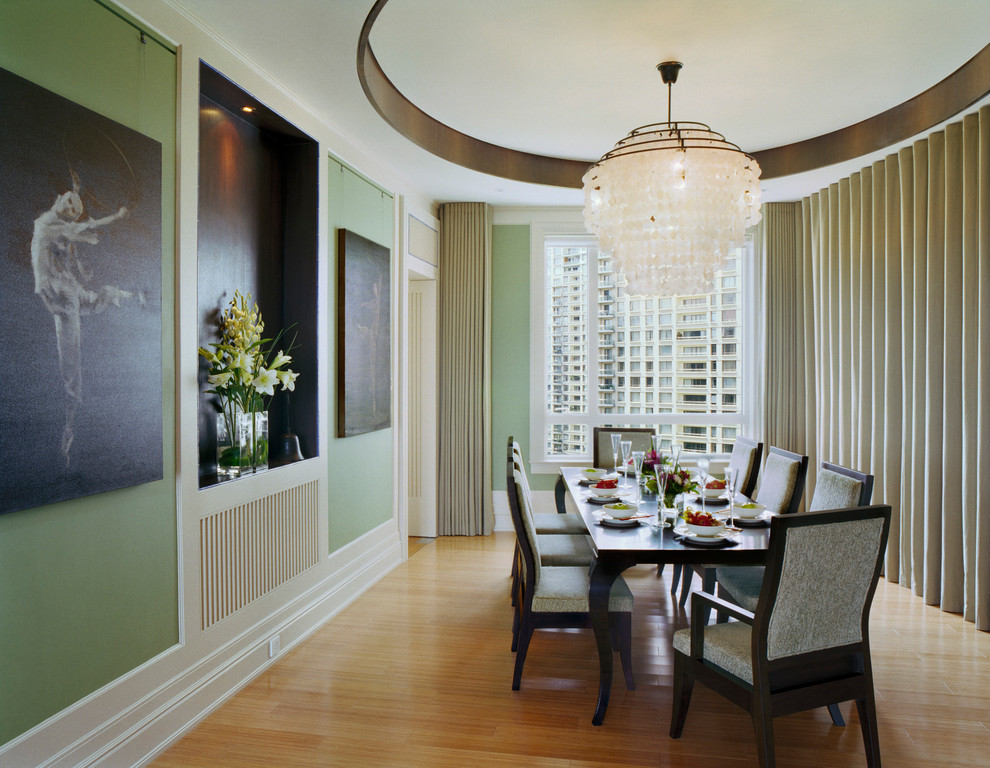Photo of a contemporary enclosed dining room in New York with green walls and medium hardwood flooring.