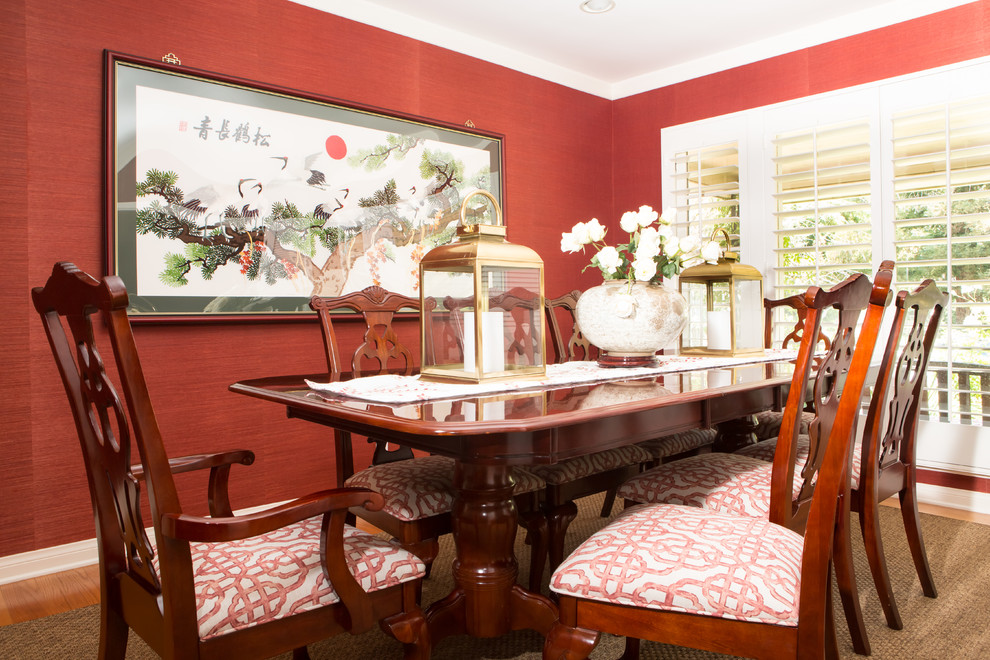 Esempio di una sala da pranzo chic chiusa e di medie dimensioni con pareti rosse, pavimento in legno massello medio e nessun camino