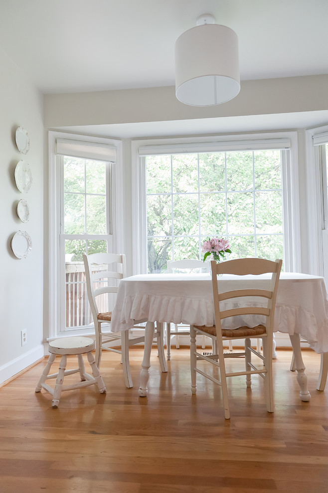 Exemple d'une salle à manger romantique avec un mur blanc et un sol en bois brun.