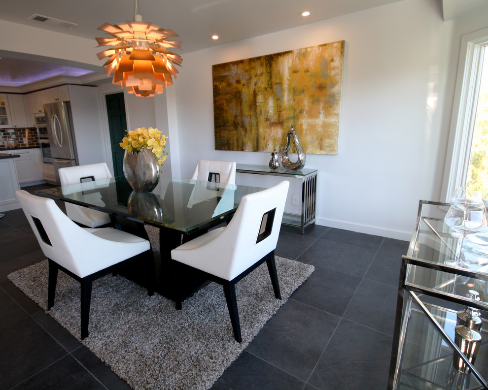 Cette image montre une salle à manger ouverte sur la cuisine minimaliste de taille moyenne avec un mur blanc et un sol en ardoise.
