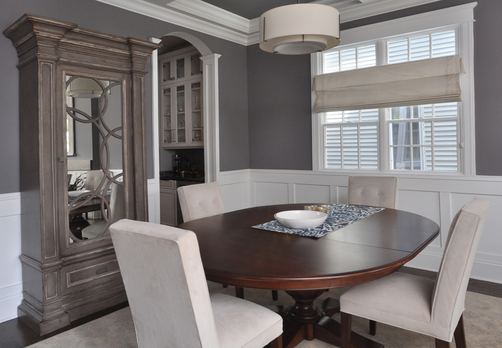 На фото: кухня-столовая среднего размера в стиле неоклассика (современная классика) с серыми стенами, темным паркетным полом, стандартным камином, фасадом камина из камня и коричневым полом с