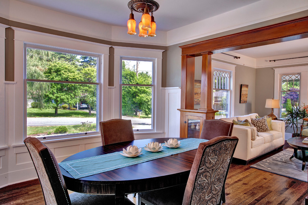 Cette photo montre une salle à manger craftsman avec un mur marron, parquet foncé et éclairage.