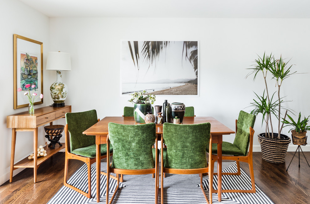 Example of an island style medium tone wood floor dining room design in Seattle with white walls