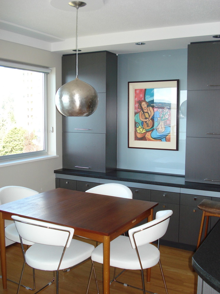 Réalisation d'une petite salle à manger ouverte sur la cuisine minimaliste avec un mur gris, parquet clair et aucune cheminée.