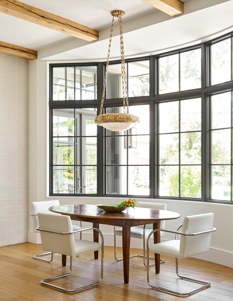 Dining room - transitional medium tone wood floor and brown floor dining room idea in Dallas with white walls