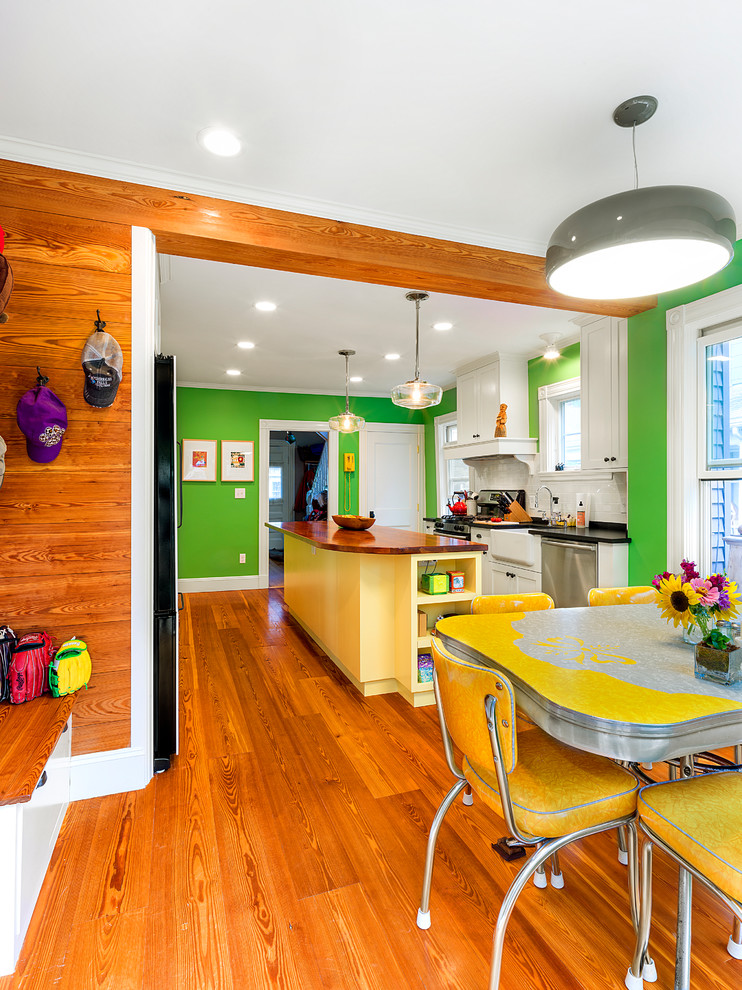 Réalisation d'une petite salle à manger ouverte sur la cuisine bohème avec un mur vert et parquet clair.