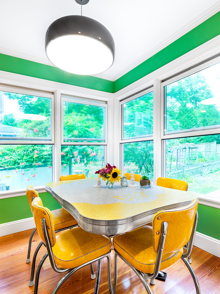 Foto di una piccola sala da pranzo aperta verso la cucina bohémian con pareti verdi e parquet chiaro