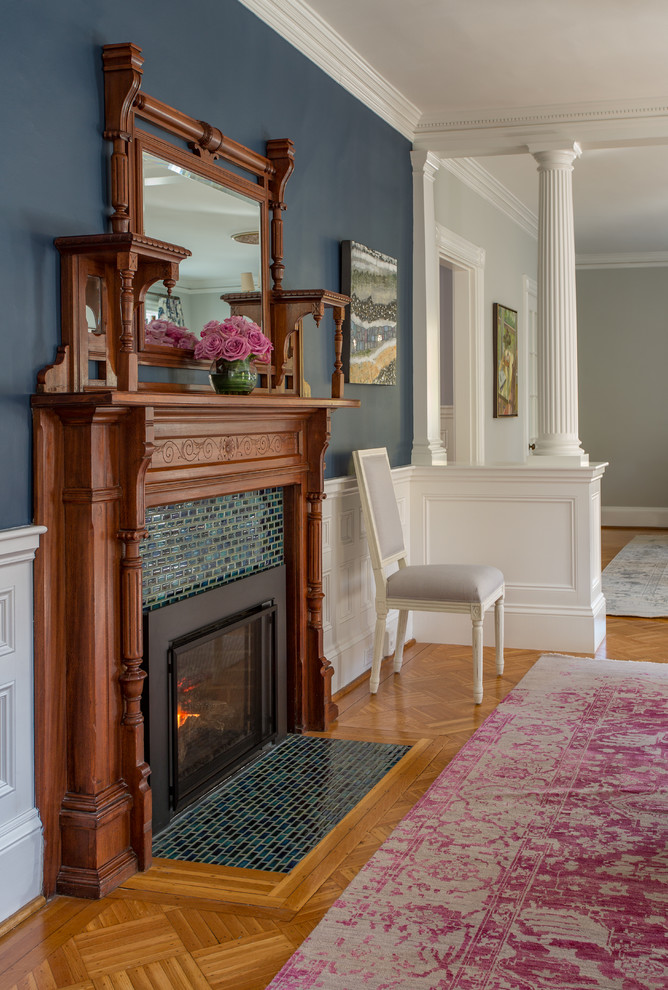 Klassisches Esszimmer mit blauer Wandfarbe, braunem Holzboden und Kamin in Boston