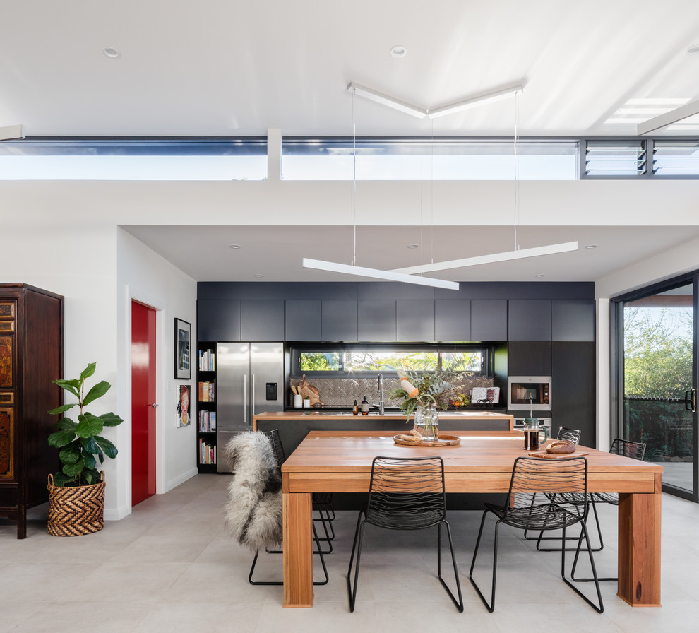 Contemporary open plan dining room in Sydney with white walls, concrete flooring and grey floors.