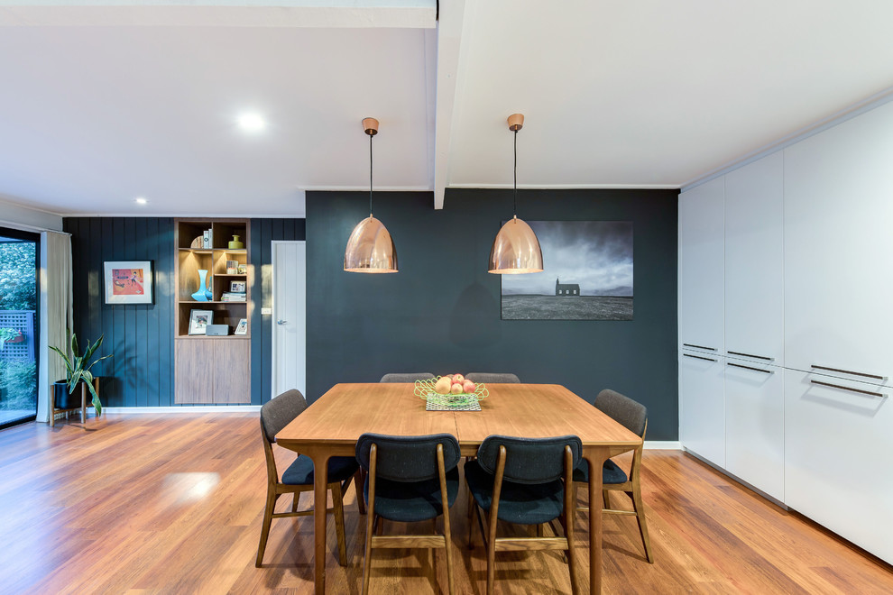 Diseño de comedor contemporáneo con paredes negras, suelo de madera en tonos medios y suelo marrón