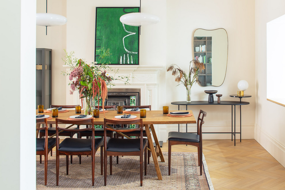 Immagine di una sala da pranzo tradizionale chiusa con pareti bianche, parquet chiaro, camino classico e pavimento beige