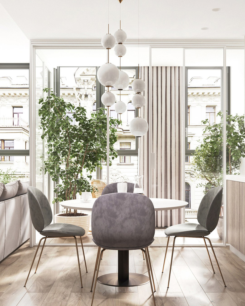 Immagine di una sala da pranzo aperta verso la cucina nordica di medie dimensioni con parquet chiaro