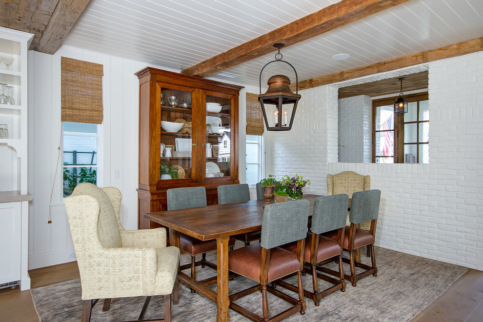 Geschlossenes, Mittelgroßes Landhaus Esszimmer ohne Kamin mit weißer Wandfarbe, hellem Holzboden und braunem Boden in Orange County