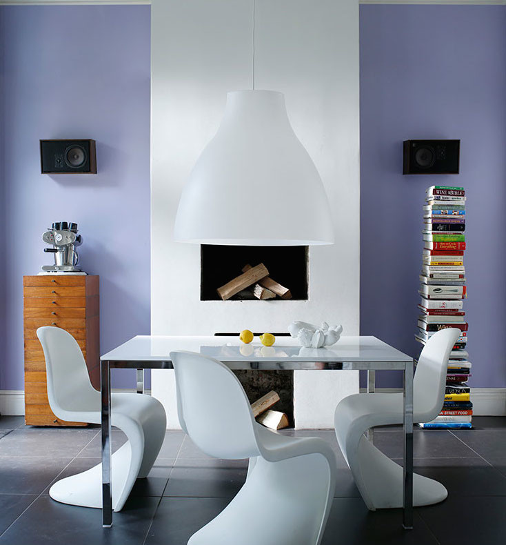 Inspiration pour une salle à manger bohème fermée et de taille moyenne avec un mur violet, un sol en carrelage de porcelaine, une cheminée standard et un manteau de cheminée en plâtre.