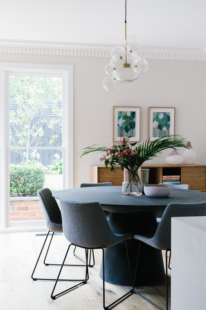 Ispirazione per una sala da pranzo aperta verso la cucina classica di medie dimensioni con pareti bianche, parquet chiaro e pavimento beige