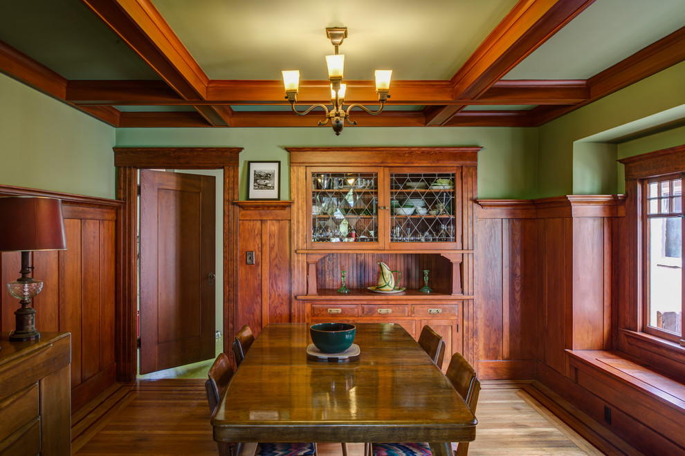 На фото: отдельная столовая в стиле кантри с зелеными стенами, паркетным полом среднего тона и коричневым полом с