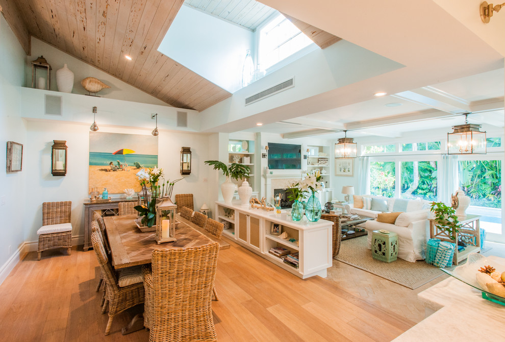 Idee per una sala da pranzo aperta verso il soggiorno costiera con pareti bianche e pavimento in legno massello medio