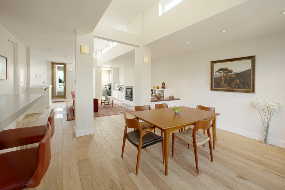 Idées déco pour une salle à manger contemporaine fermée et de taille moyenne avec un mur blanc, parquet clair, aucune cheminée et un sol marron.