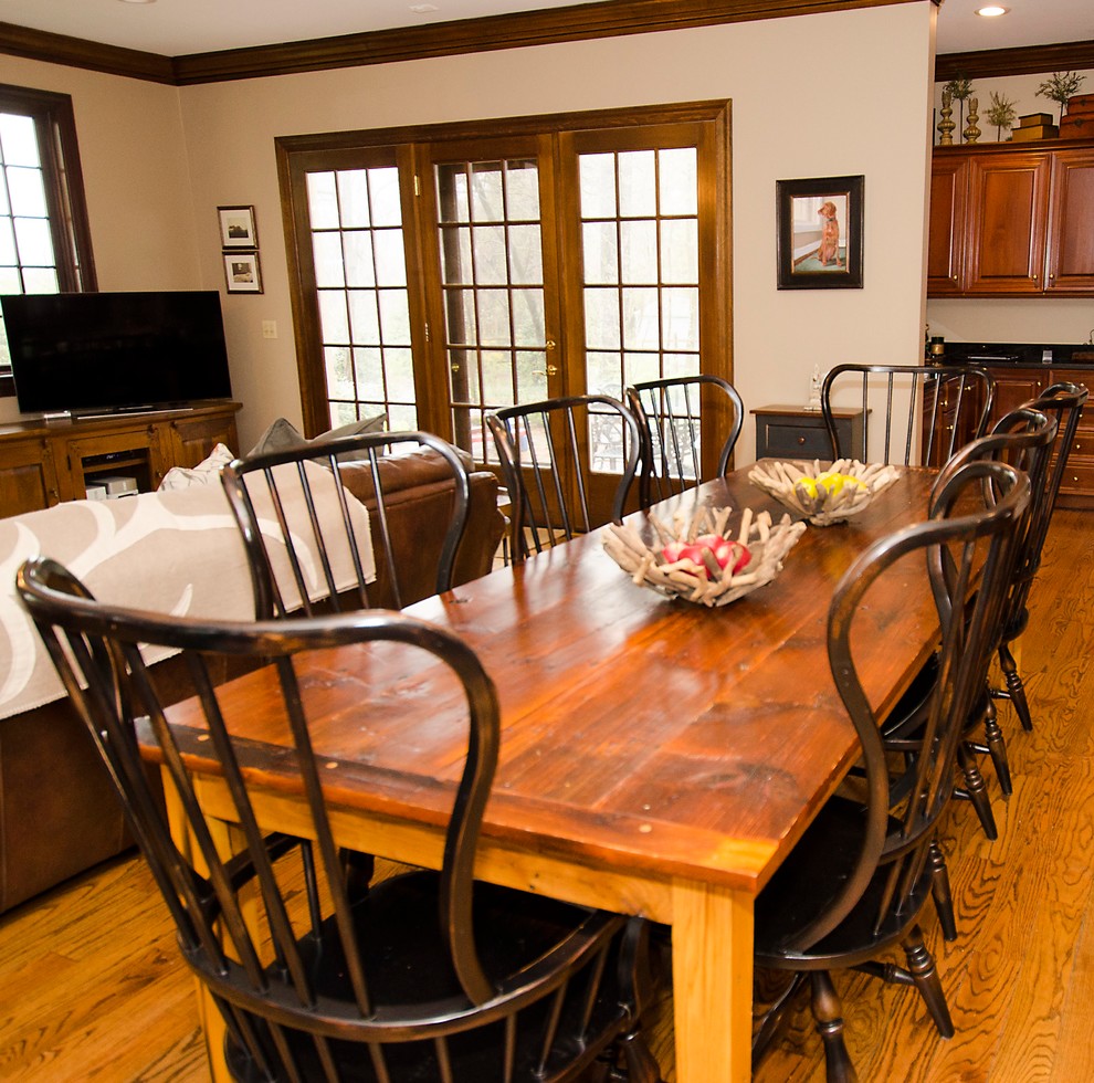Foto di una sala da pranzo aperta verso il soggiorno chic di medie dimensioni con pareti beige, pavimento in legno massello medio, nessun camino e pavimento marrone