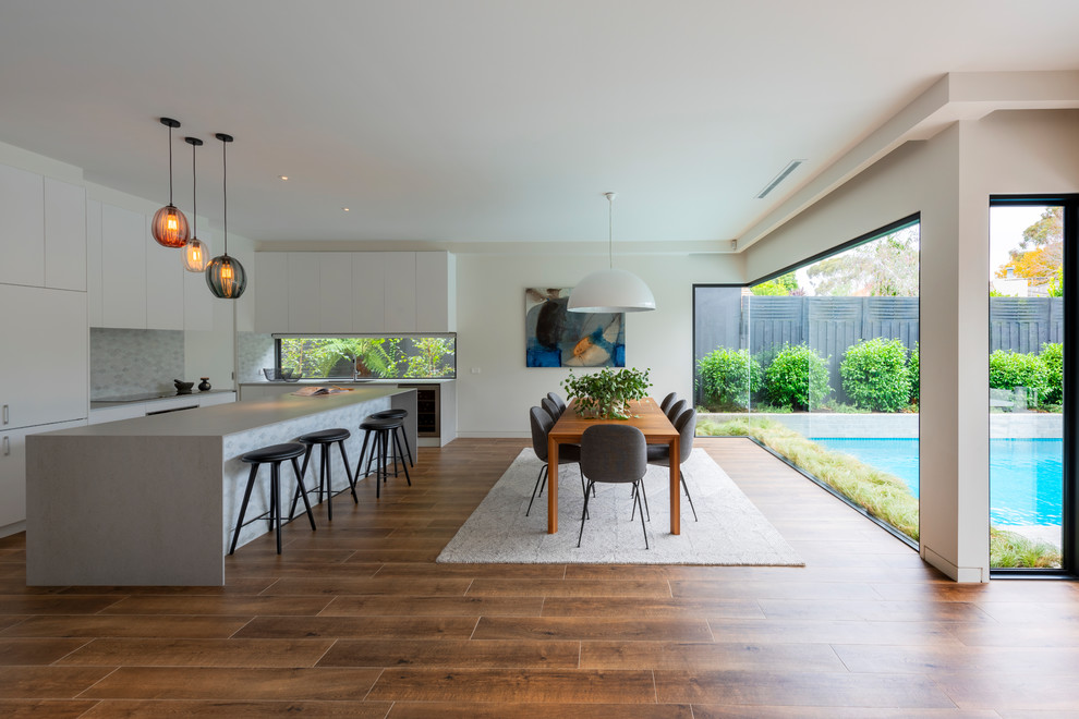 Moderne Wohnküche mit braunem Boden, weißer Wandfarbe und Porzellan-Bodenfliesen in Melbourne