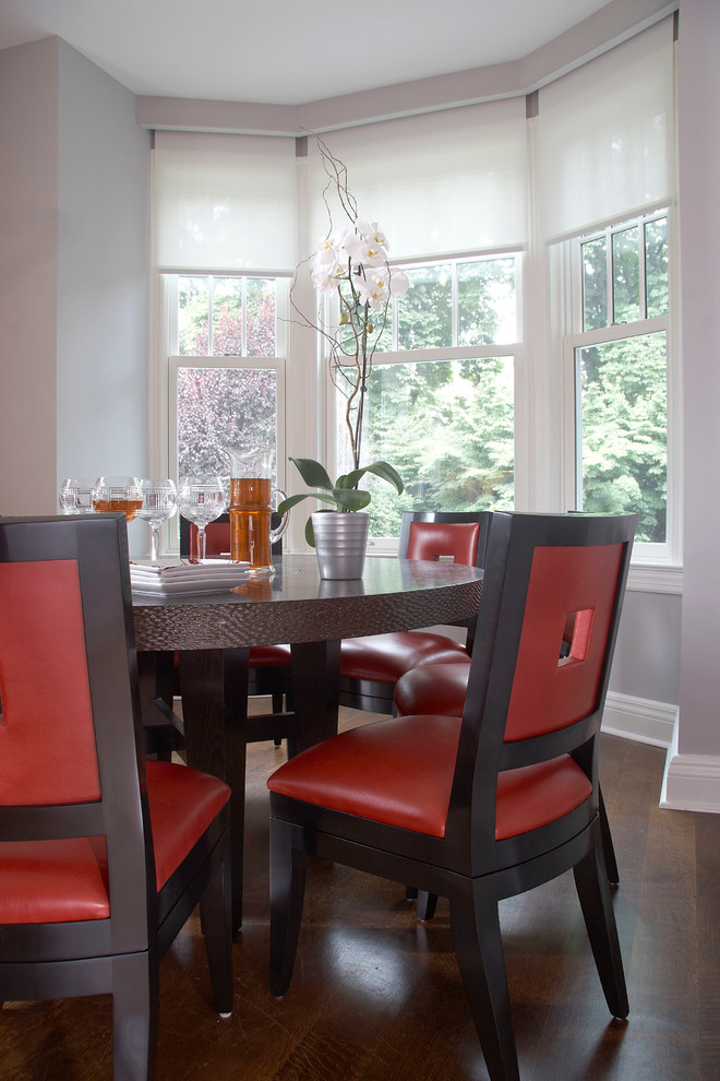 Exemple d'une salle à manger ouverte sur la cuisine éclectique de taille moyenne avec un mur gris, parquet foncé et aucune cheminée.