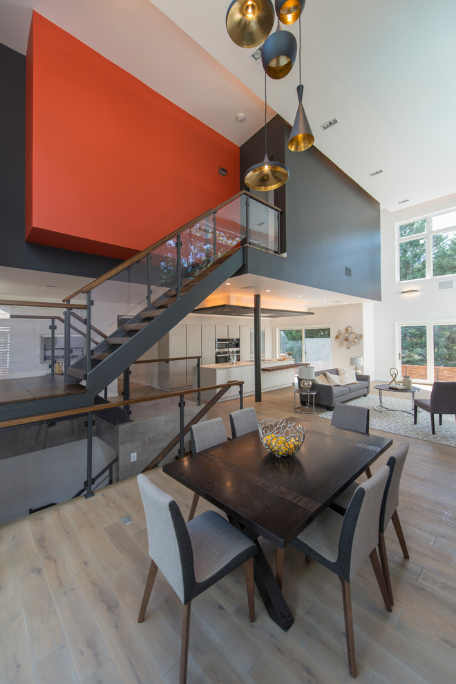 Идея дизайна: гостиная-столовая в современном стиле с оранжевыми стенами и серым полом