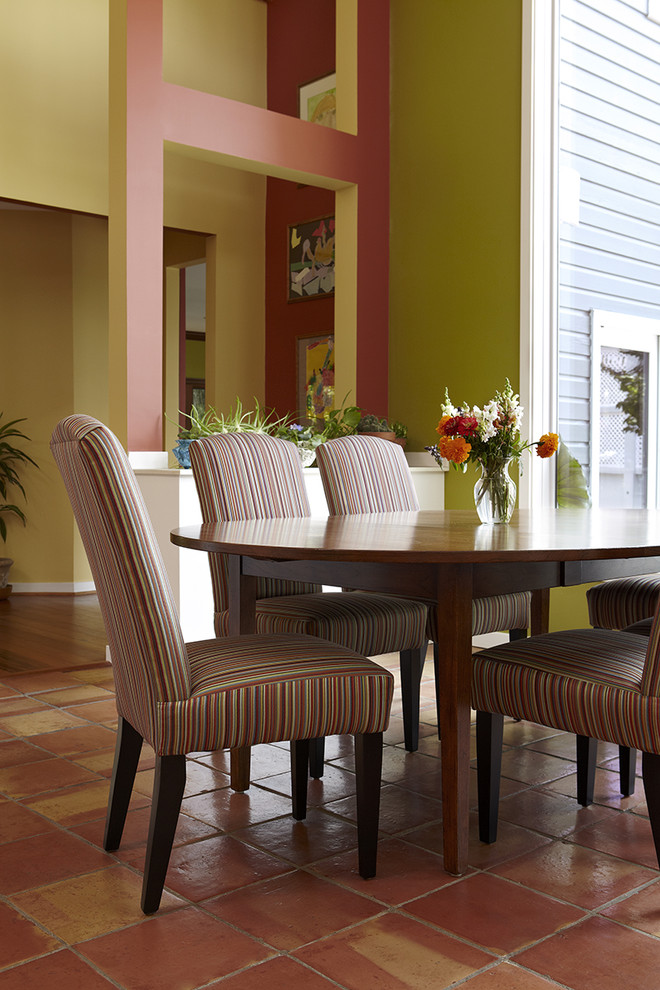 На фото: кухня-столовая среднего размера в стиле неоклассика (современная классика) с зелеными стенами, полом из терракотовой плитки и оранжевым полом без камина с