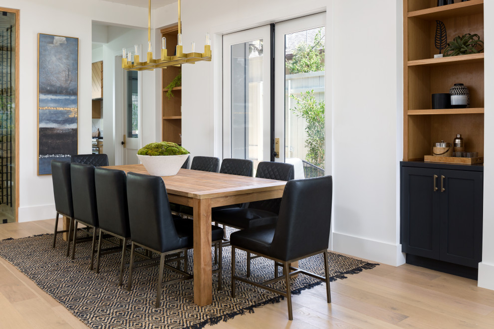 This is an example of a medium sized traditional kitchen/dining room in Los Angeles with white walls, light hardwood flooring and beige floors.