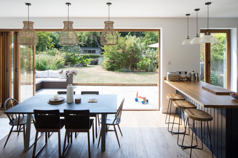 Aménagement d'une salle à manger ouverte sur la cuisine contemporaine de taille moyenne avec un mur blanc, parquet clair et un sol beige.