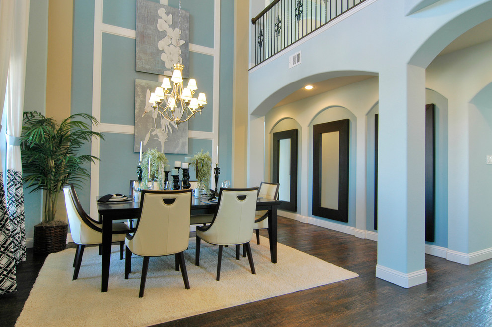 This is an example of a traditional dining room in Dallas with blue walls and dark hardwood flooring.