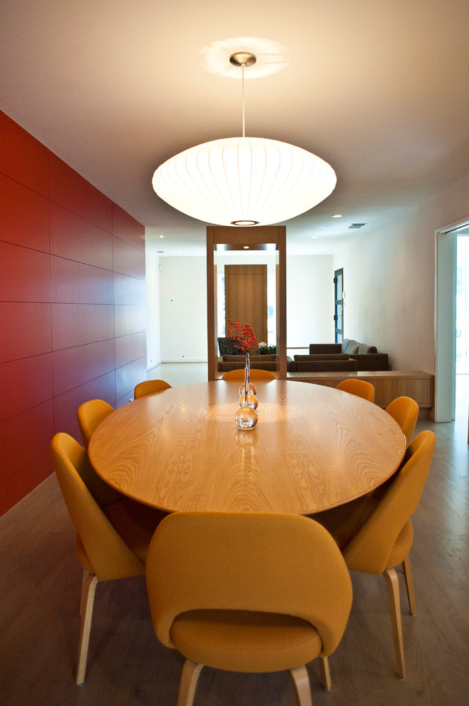 Идея дизайна: столовая в современном стиле с красными стенами и темным паркетным полом