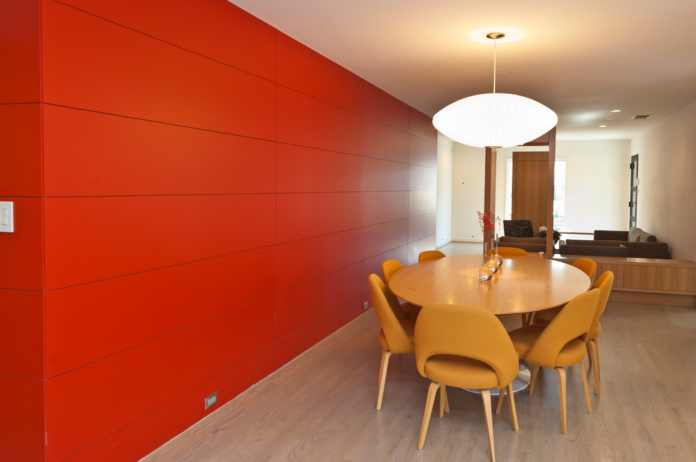 Example of a trendy medium tone wood floor dining room design in Dallas with red walls