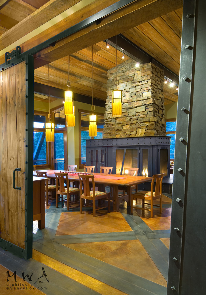 Inspiration pour une salle à manger design avec un mur beige, sol en béton ciré, une cheminée double-face, un manteau de cheminée en métal et un sol multicolore.