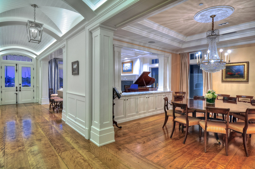 Foto di una grande sala da pranzo aperta verso il soggiorno classica con pavimento in legno massello medio e pareti gialle