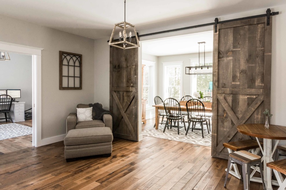 Ejemplo de comedor de estilo de casa de campo pequeño cerrado sin chimenea con suelo de madera en tonos medios, suelo marrón y paredes grises