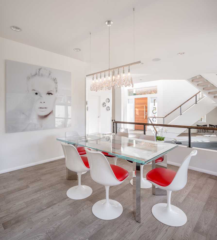Immagine di una sala da pranzo contemporanea chiusa con pareti bianche, parquet chiaro e pavimento grigio