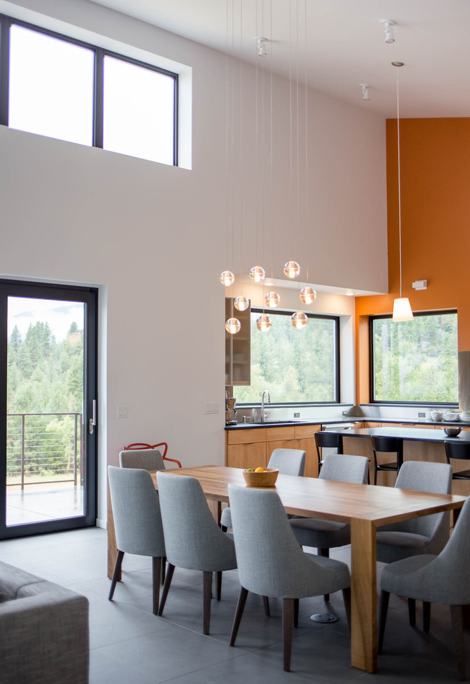 Foto på en stor funkis matplats med öppen planlösning, med vita väggar, skiffergolv och en spiselkrans i trä