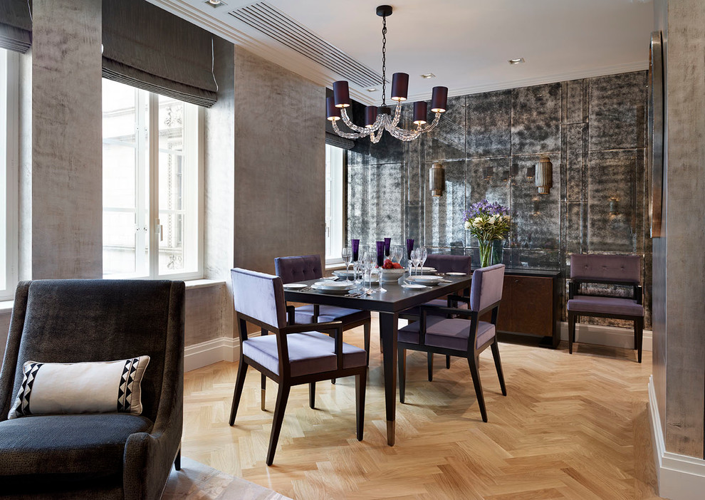 Immagine di una sala da pranzo design chiusa con pareti con effetto metallico e parquet chiaro