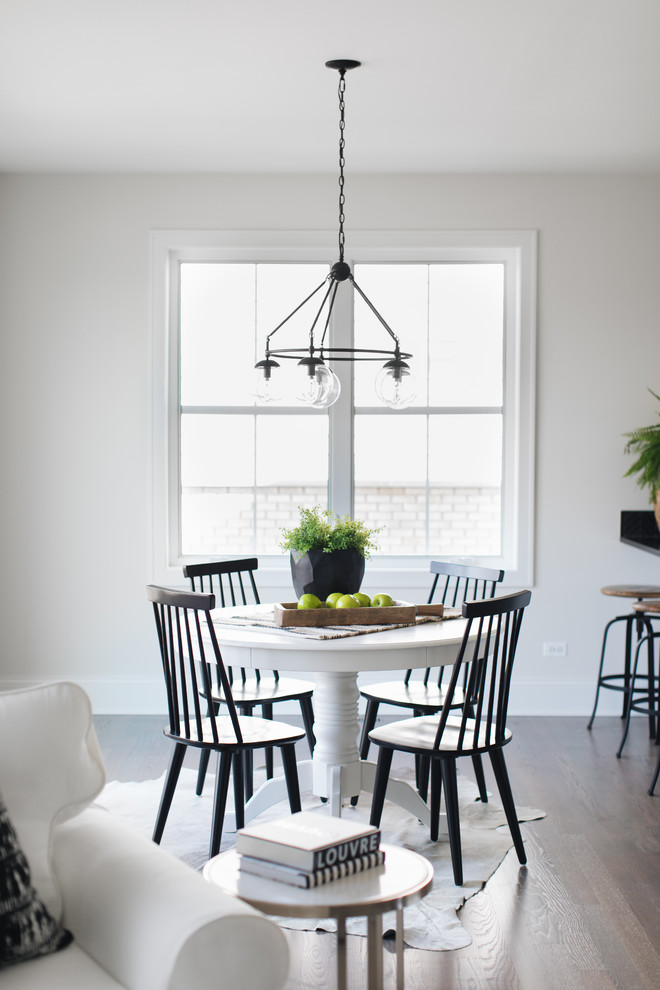 Inspiration for a traditional open plan dining room in Chicago with white walls and light hardwood flooring.