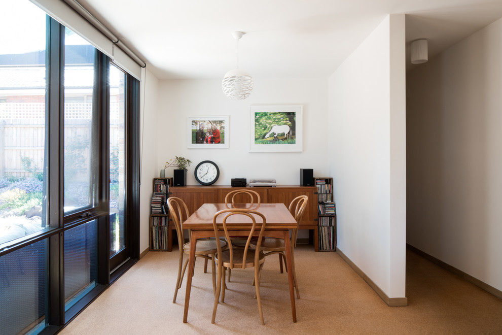 Foto di una piccola sala da pranzo aperta verso il soggiorno minimalista con pareti bianche, pavimento in sughero e pavimento beige