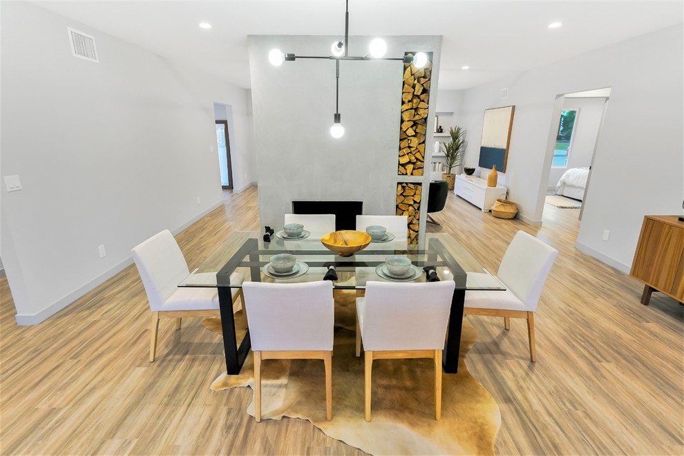 Mittelgroße Moderne Wohnküche mit grauer Wandfarbe, Vinylboden, Kamin, Kaminumrandung aus Beton und braunem Boden in Los Angeles