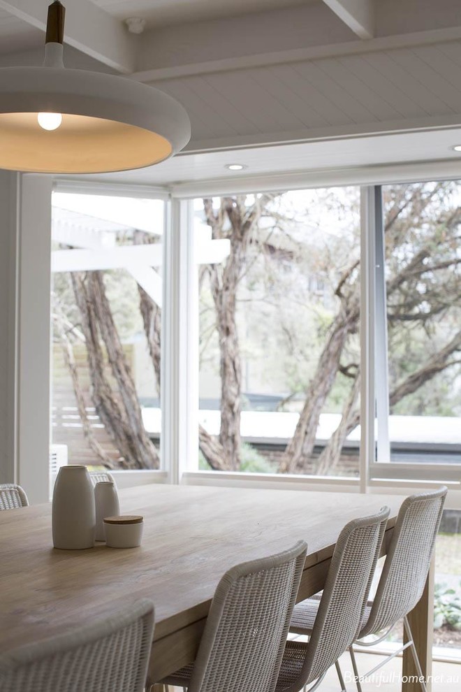 Cette image montre une salle à manger ouverte sur le salon design de taille moyenne avec un mur blanc et parquet clair.